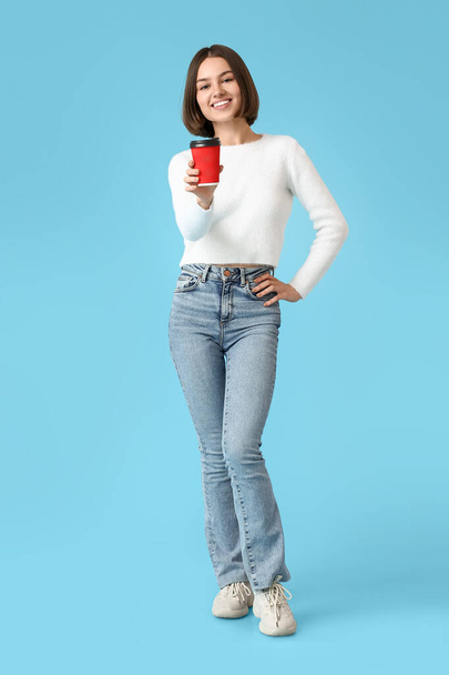Krásná žena s šálkem kávy na barevném pozadí - Fotografie, Obrázek