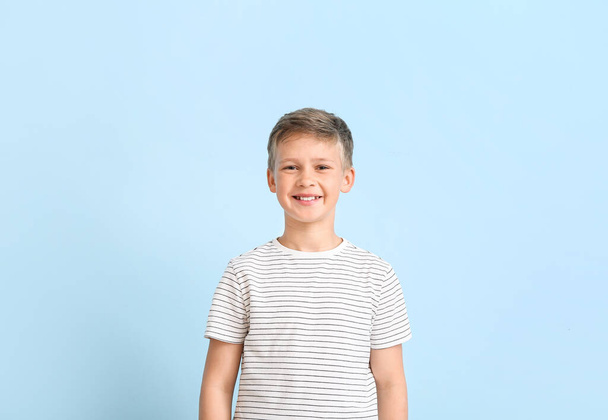 Portret van glimlachend jongetje op blauwe achtergrond - Foto, afbeelding