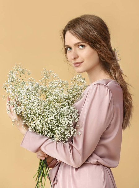 Mujer joven bonita con ramo de flores sobre fondo de color - Foto, Imagen