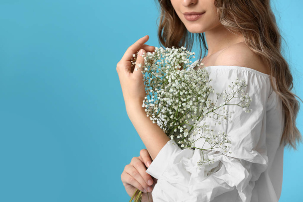 Pretty young woman with bouquet of flowers on color background - Foto, immagini