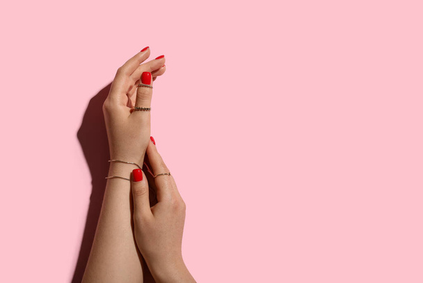 Vrouwelijke handen met mooie manicure en stijlvolle sieraden op kleur achtergrond - Foto, afbeelding