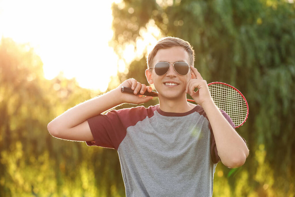 Jonge mannelijke badminton speler buiten - Foto, afbeelding