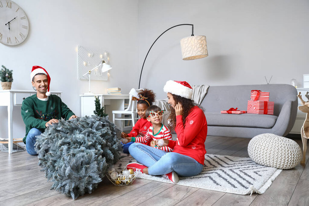 Ευτυχισμένη οικογένεια με παιδιά που στολίζουν χριστουγεννιάτικο δέντρο στο σπίτι - Φωτογραφία, εικόνα