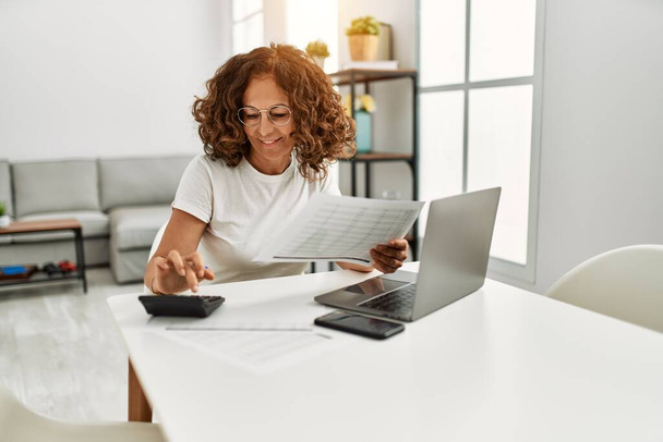 Middle age hispanic woman smiling confident working at home - Photo, Image