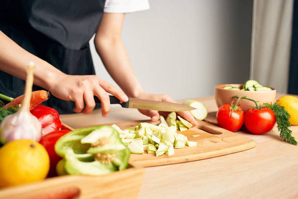 woman in apron cuts vegetables healthy food lifestyle - Foto, imagen