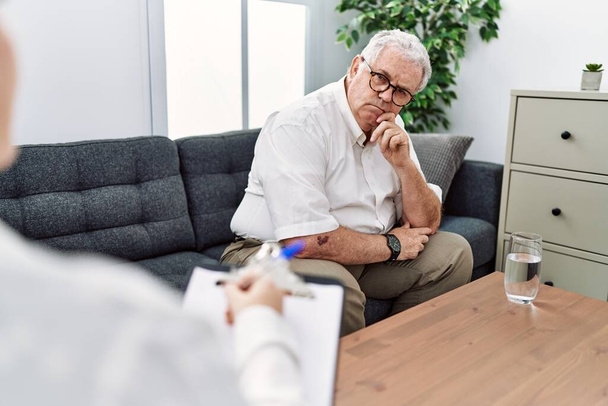 Middle age grey-haired man having psychology session at psychology clinic - Photo, Image