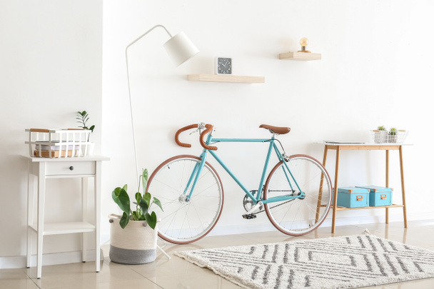 Интерьер светлой гостиной с велосипедом и столом - Фото, изображение