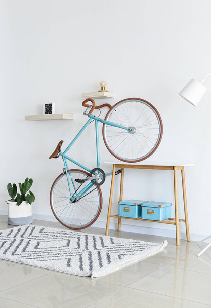 Fahrrad und Tisch mit Boxen in der Nähe der weißen Wand - Foto, Bild