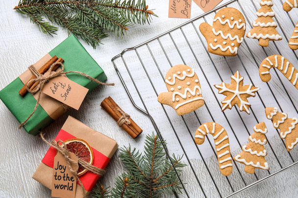 Rejilla con galletas de jengibre de Navidad y regalos sobre fondo claro - Foto, imagen