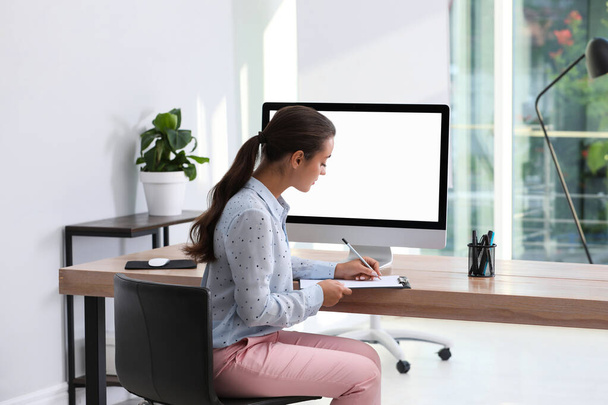 Young woman working at table in modern office - Foto, Imagen