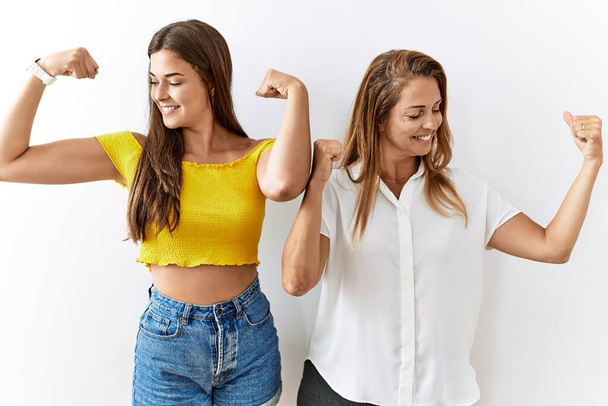 Mother and daughter together standing together over isolated background showing arms muscles smiling proud. fitness concept.  - Φωτογραφία, εικόνα