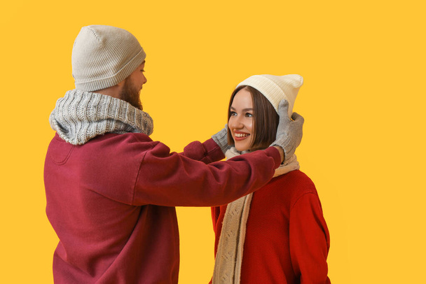 Young couple in stylish winter clothes on color background - Photo, image