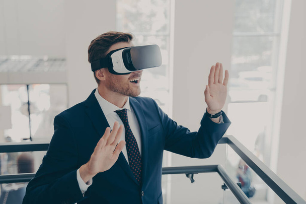 Zakenman in pak met virtual reality bril op kantoor - Foto, afbeelding