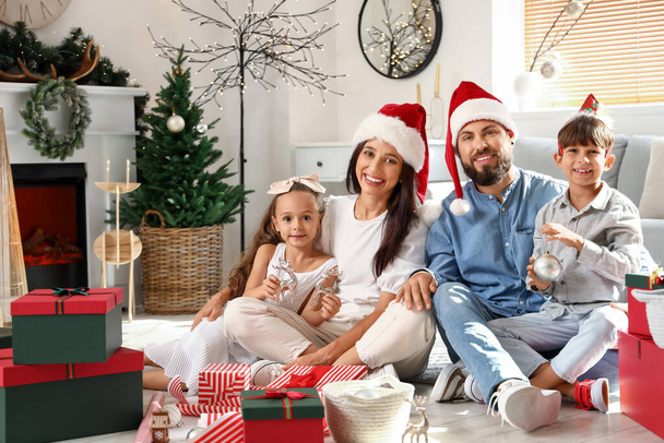 Ευτυχισμένη οικογένεια με χαριτωμένα μικρά παιδιά γιορτάζει τα Χριστούγεννα στο σπίτι - Φωτογραφία, εικόνα