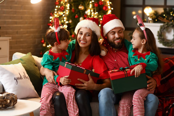 Ευτυχισμένη οικογένεια με παιδιά και δώρα στο σπίτι παραμονή Χριστουγέννων - Φωτογραφία, εικόνα
