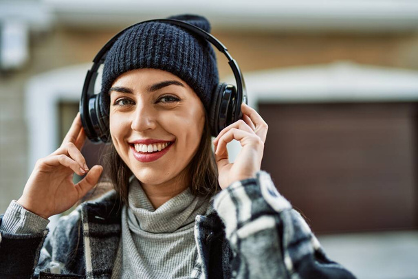 Young hispanic woman smiling happy using headphones at the city. - Foto, Imagem