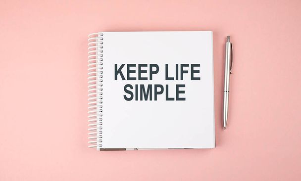 KEEP LIFE SIMPLE text on notebook with pen on pink background - Photo, Image