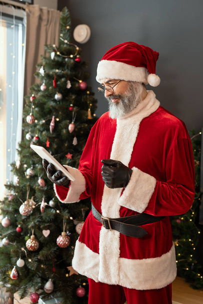 Serious Santa Checking Email On Tablet - Valokuva, kuva