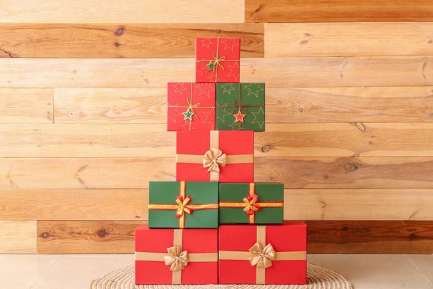 Molte scatole regalo di Natale vicino alla parete di legno - Foto, immagini