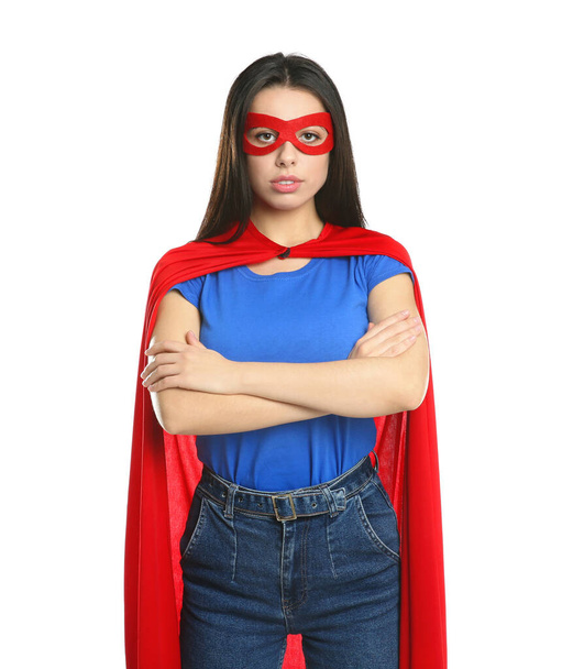 Confident young woman wearing superhero cape and mask on white background - Фото, зображення