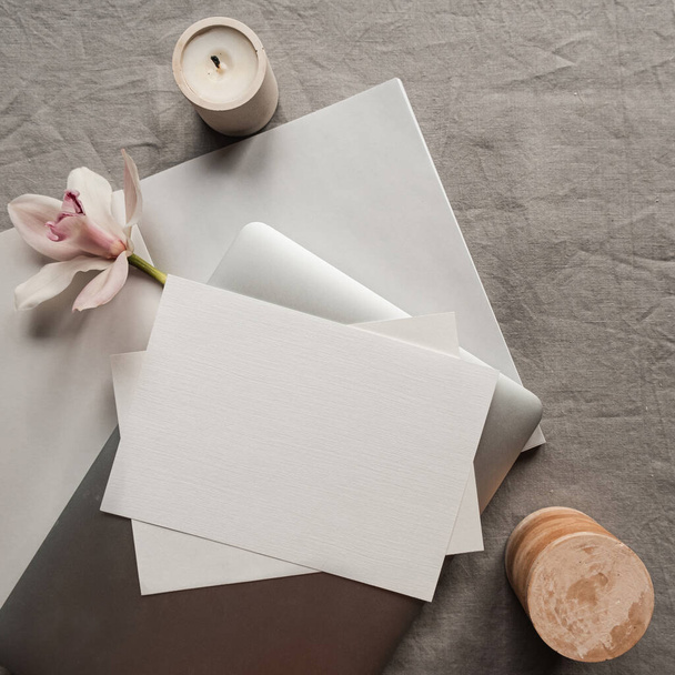Prázdná papírová karta s makupem kopírovací prostor, notebook, růžová květina, svíčka na neutrálním plátně pozadí. Minimální estetická obchodní značka, svatební pozvánka šablona. Byt ležel, horní pohled - Fotografie, Obrázek
