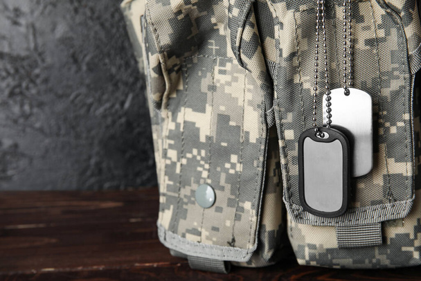 Saco militar e etiquetas no fundo escuro, close-up - Foto, Imagem