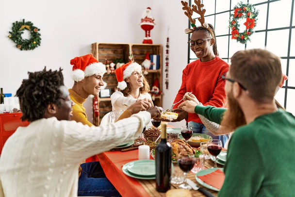 Gruppo di giovani sorridenti felici di avere la cena di Natale a casa. - Foto, immagini
