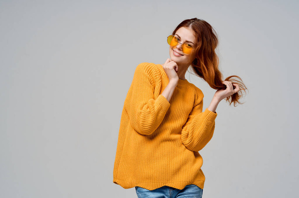 κοκκινομάλλα γυναίκα με κίτρινα γυαλιά θέτει διασκεδαστικό τρόπο ζωής μοντέλο στούντιο - Φωτογραφία, εικόνα