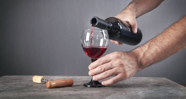 vörösbor öntése az üvegbe. - Fotó, kép