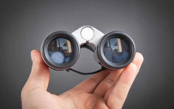 Mano masculina mostrando binoculares. Accesorio de senderismo - Foto, Imagen