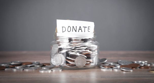 Glass jar with coins and Donate word. - Zdjęcie, obraz