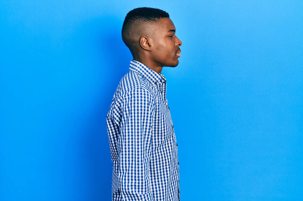 Young african american man wearing casual clothes looking to side, relax profile pose with natural face with confident smile.  - Fotoğraf, Görsel