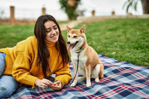 Mooie jonge vrouw met shiba inu hond in park - Foto, afbeelding