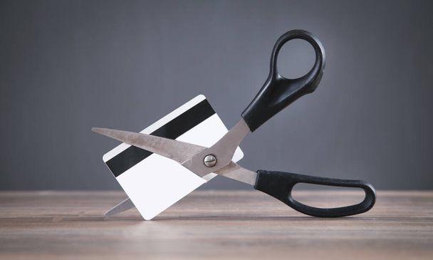 Black scissors cutting a credit card. - Fotoğraf, Görsel