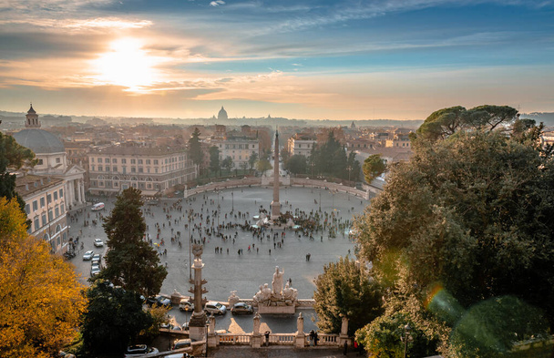 Piazza del Popolo ve večerních hodinách, s Vatikánský dóm v pozadí. Fotografie pořízená z Terrazza del Pincio. Scénický západ slunce v Římě, Itálie. - Fotografie, Obrázek