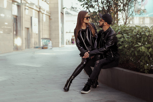 Beautiful couple sits on a bench and looks at each others in the city - Foto, imagen