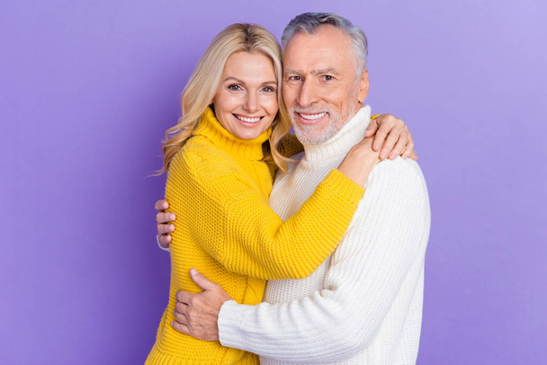 Photo of dreamy charming mature wife husband wear knitted pullovers smiling embracing isolated purple color background - Foto, immagini