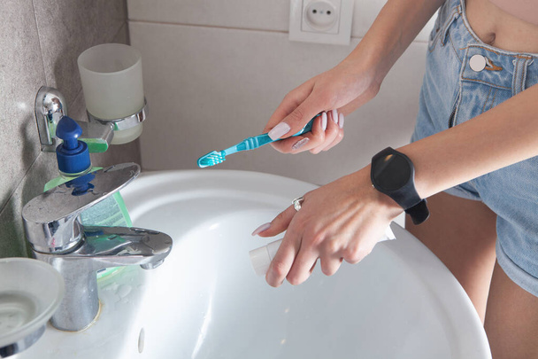 Mujer joven sosteniendo el cepillo de dientes antes de cepillarse los dientes. - Foto, imagen