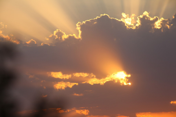 Raios solares através das nuvens ao pôr do sol
 - Foto, Imagem