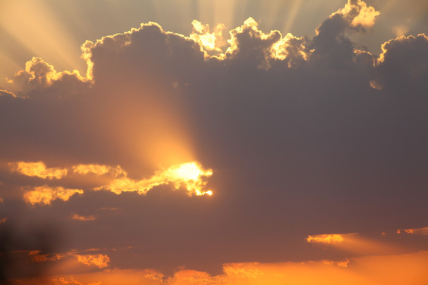 ακτίνες του ήλιου μέσα από τα σύννεφα στο ηλιοβασίλεμα - Φωτογραφία, εικόνα