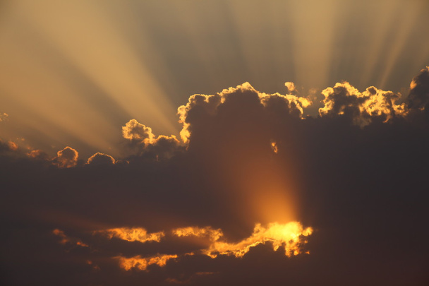 Rayos de sol a través de las nubes al atardecer
 - Foto, imagen
