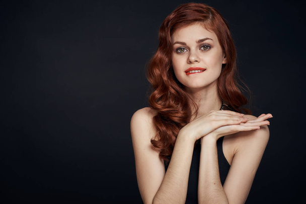 attractive red-haired woman in a black dress hairstyle dark background - Fotó, kép