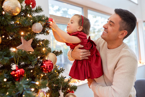 happy father and baby girl decorate christmas tree - Foto, Imagem