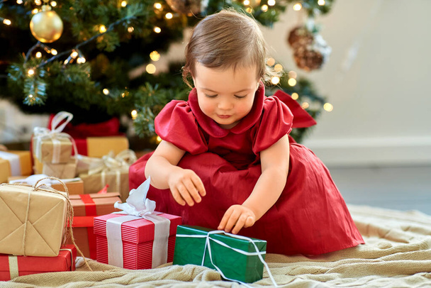 happy baby girl opening christmas gifts at home - Photo, image