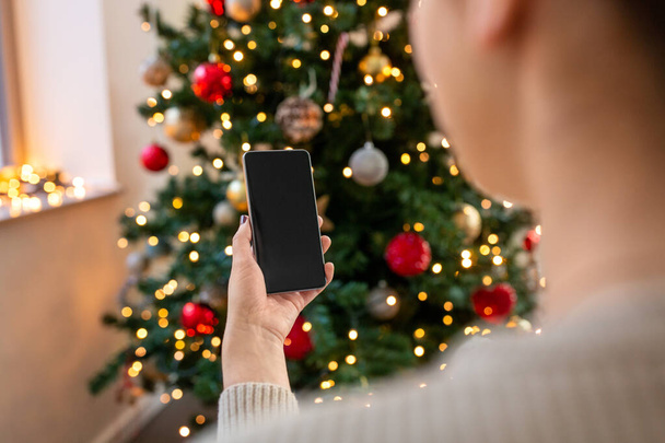 close up of woman with smartphone on christmas - Zdjęcie, obraz