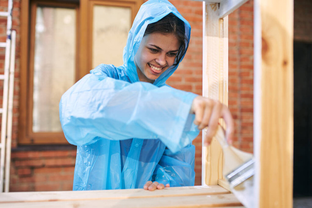 woman paints wood painter repair protective suit - Foto, afbeelding