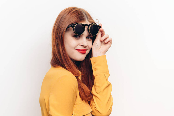 glamorous woman sunglasses red hair light background - Foto, afbeelding