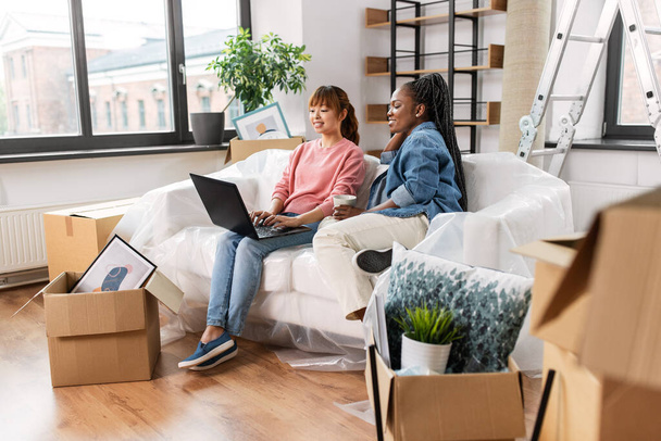 women using laptop and moving to new home - Photo, image