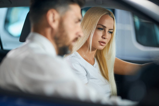 Dealer showing female customer interior of luxury auto - 写真・画像