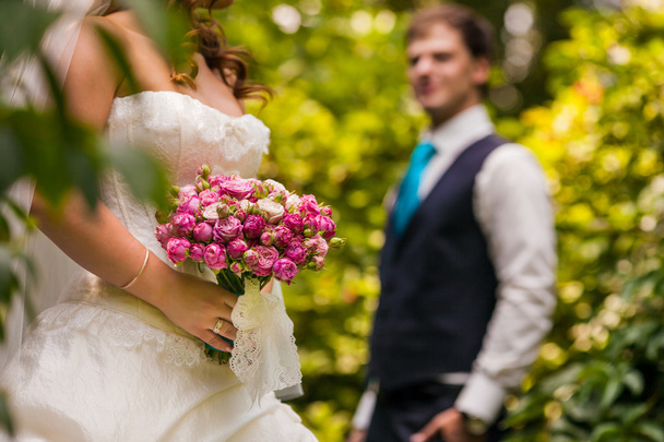 Groom looking on the bride holding bridal bouquet close up - 写真・画像